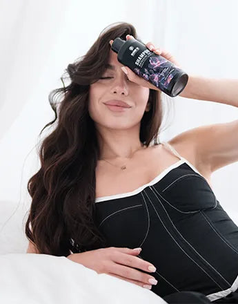 Шампоани за коса - професионален шампоан за бляскава и здрава коса в ръцете на доволна жена.