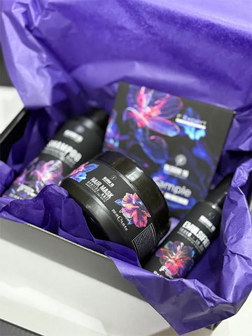 Bloom 16 Възстановяваща грижа за коса в подаръчна кутия с лилава хартия.