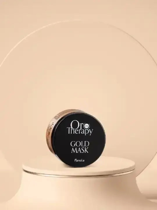 Oro therapy gold hydrating hair mask 300 ml on a minimalist display, showcasing its elegant packaging