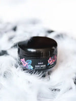 Зареди изображението в галерията, Bloom 16 Възстановяваща грижа за коса – Hair Mask, опакован в черна кутийка сред бели пера.
